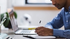 Persona che scrive con penna su agenda